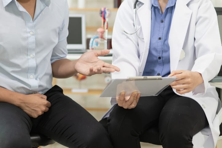 Photo shows a doctor explaining test results to a young male patient/Getty Images