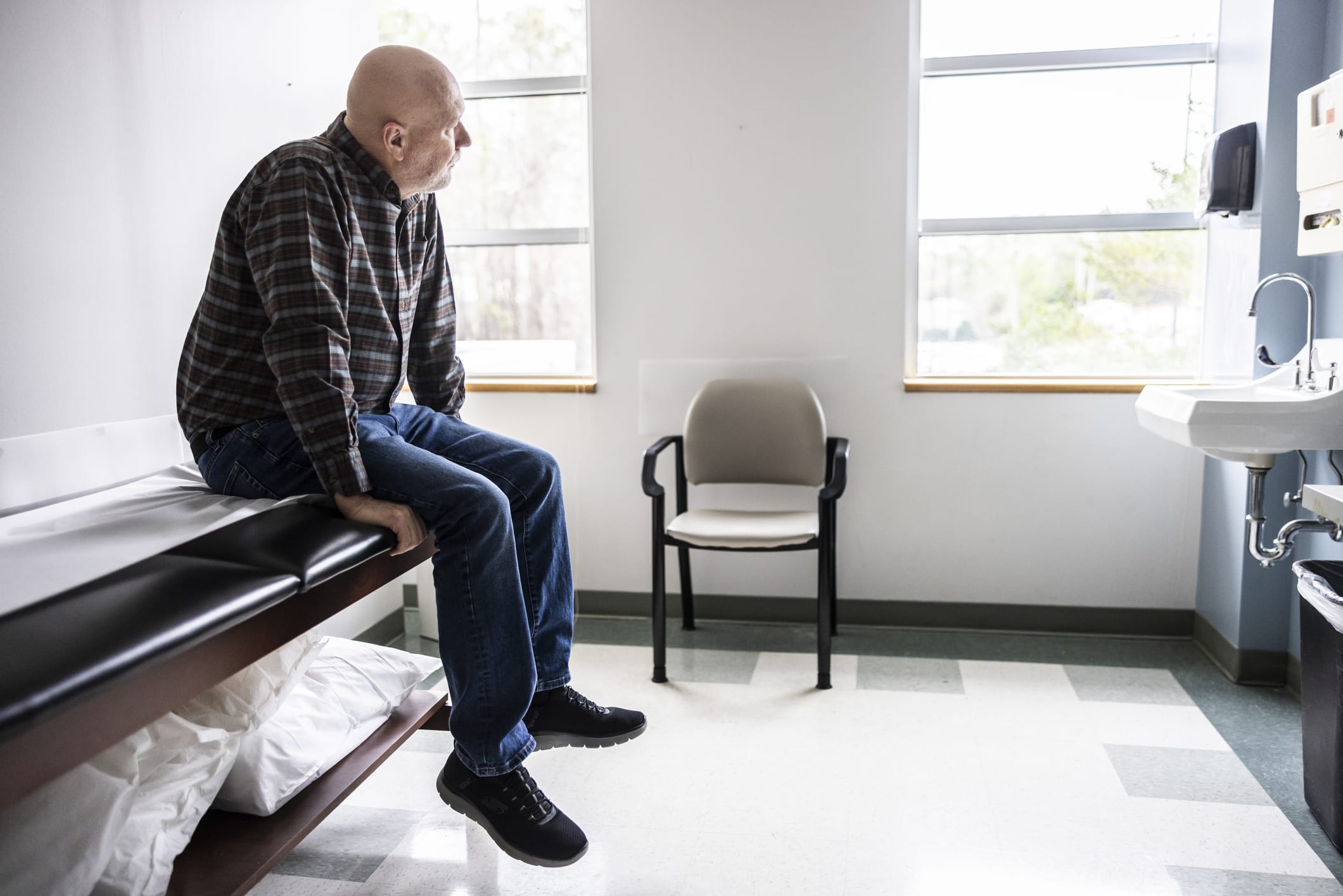 Senior man waiting in in doctors exam room